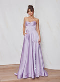 Woman wearing a strapless lavender gown with a plain background