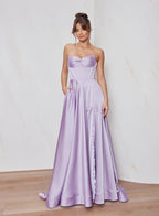 Woman wearing a strapless lavender gown with a plain background