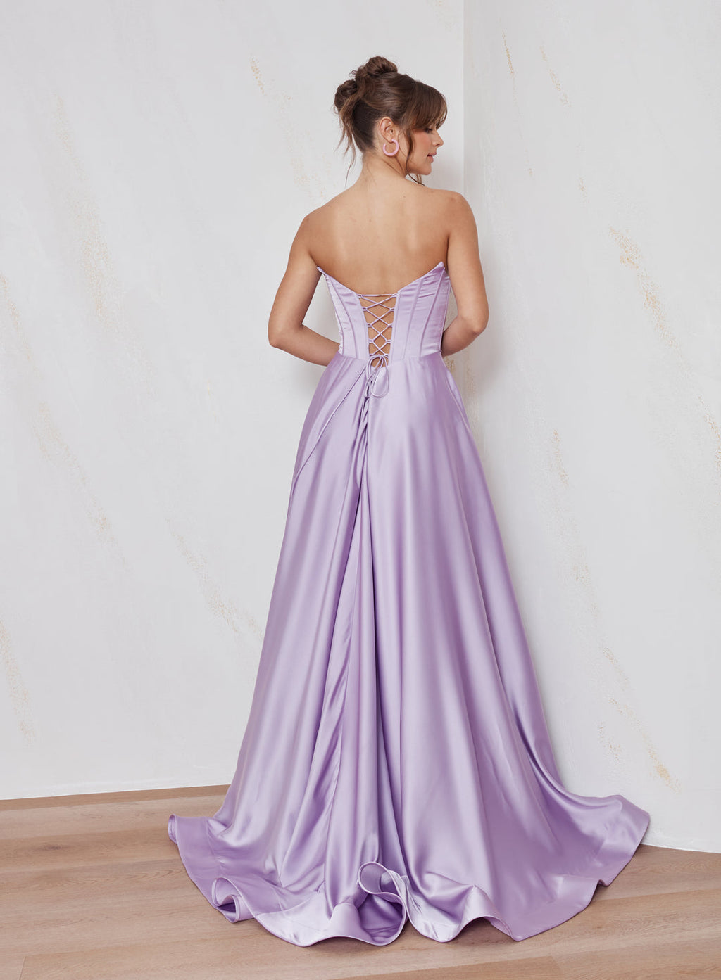 Woman wearing a purple evening gown with a white background