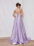 Woman wearing a purple evening gown with a white background
