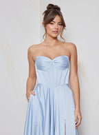 Woman wearing a light blue strapless gown against a neutral background