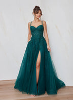 Woman wearing a green evening gown with a high slit on a white background