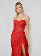 Woman wearing a red strapless gown with a slit on a light background