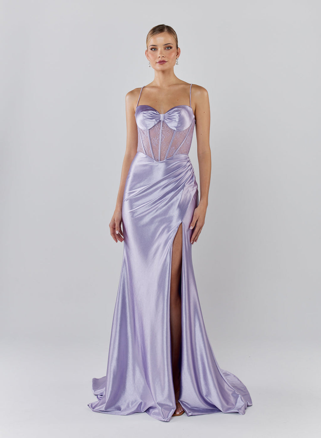 Woman wearing a lavender evening gown with a slit on a white background
