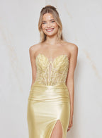 Woman wearing a strapless gold evening gown with a white background