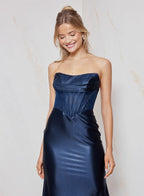 Woman wearing a strapless navy blue gown against a light background
