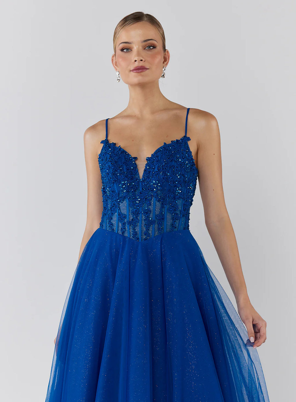 Blue evening gown with lace detailing on a white background