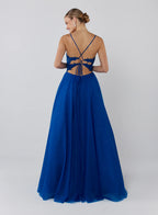 Woman wearing a blue evening gown with a lace-up back on a white background
