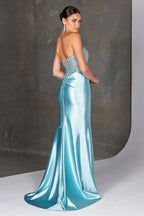 Woman wearing a light blue satin gown against a neutral background