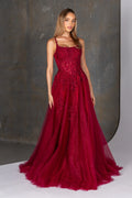 Woman wearing a red lace evening gown against a neutral background