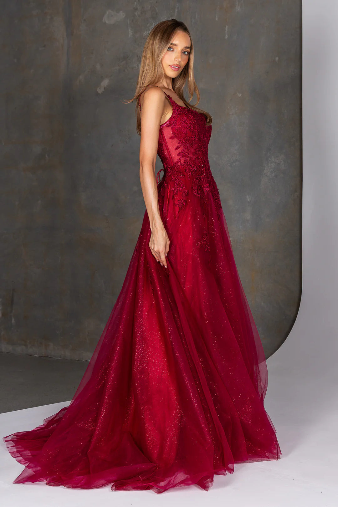 Woman wearing a red evening gown against a neutral background