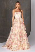 Woman wearing a strapless floral gown with ruffled layers against a neutral background