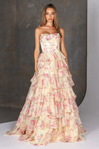 Woman wearing a strapless floral gown with ruffled layers against a neutral background