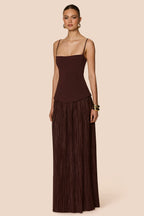 Woman wearing a brown dress with a plain background