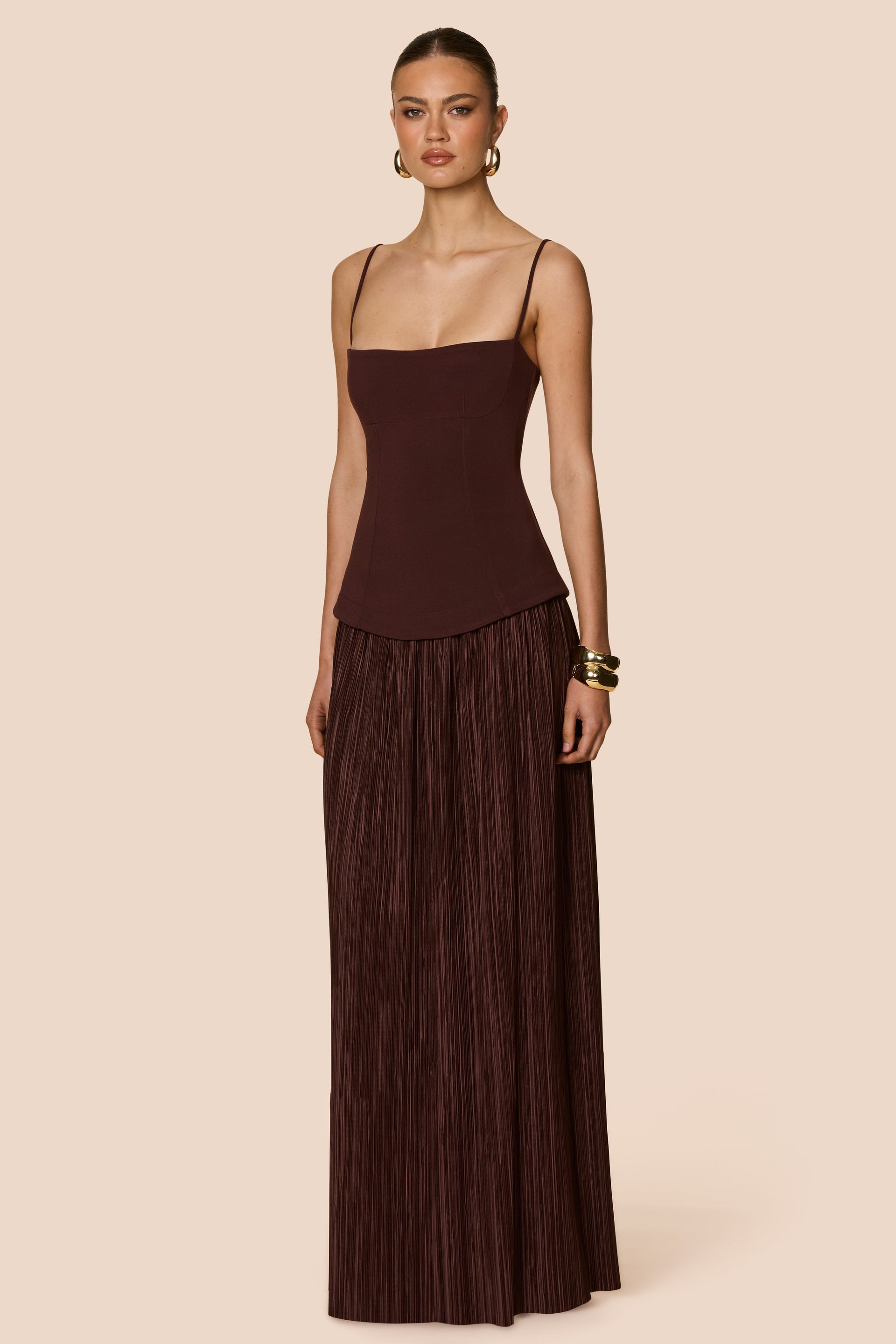Woman wearing a brown dress with a plain background