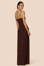 Woman wearing a brown dress with a plain background