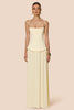 Woman wearing a strapless top and flowing skirt in a neutral setting