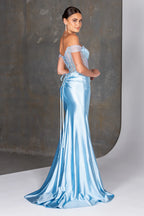 Woman wearing a light blue evening gown against a neutral background
