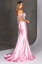 Woman wearing a pink satin evening gown against a gray background