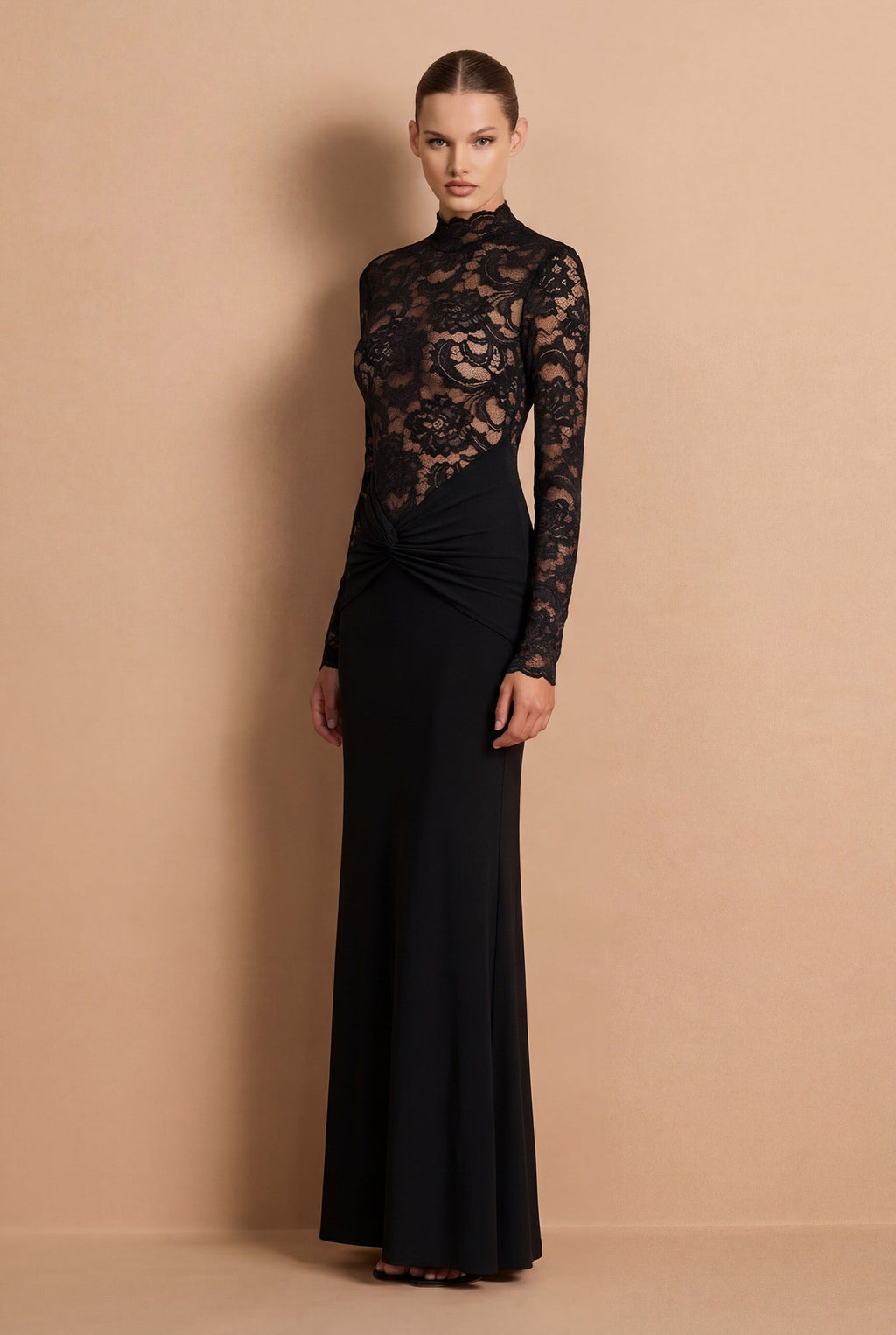 Woman wearing a black lace dress against a beige background