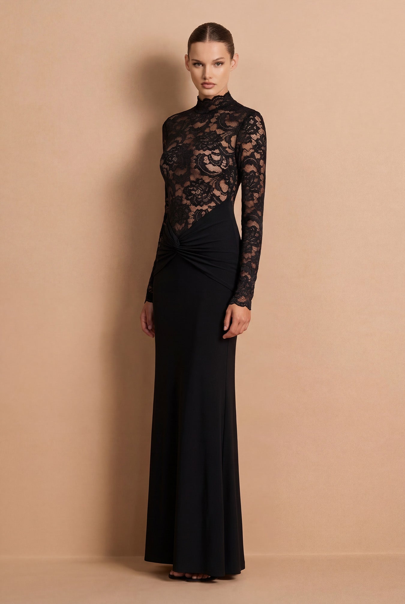 Woman wearing a black lace dress against a beige background