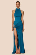 Teal evening gown with a high slit on a beige background