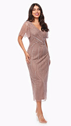 Woman wearing a rose gold dress with lace details on a white background