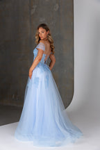 Woman wearing a light blue evening gown against a neutral background