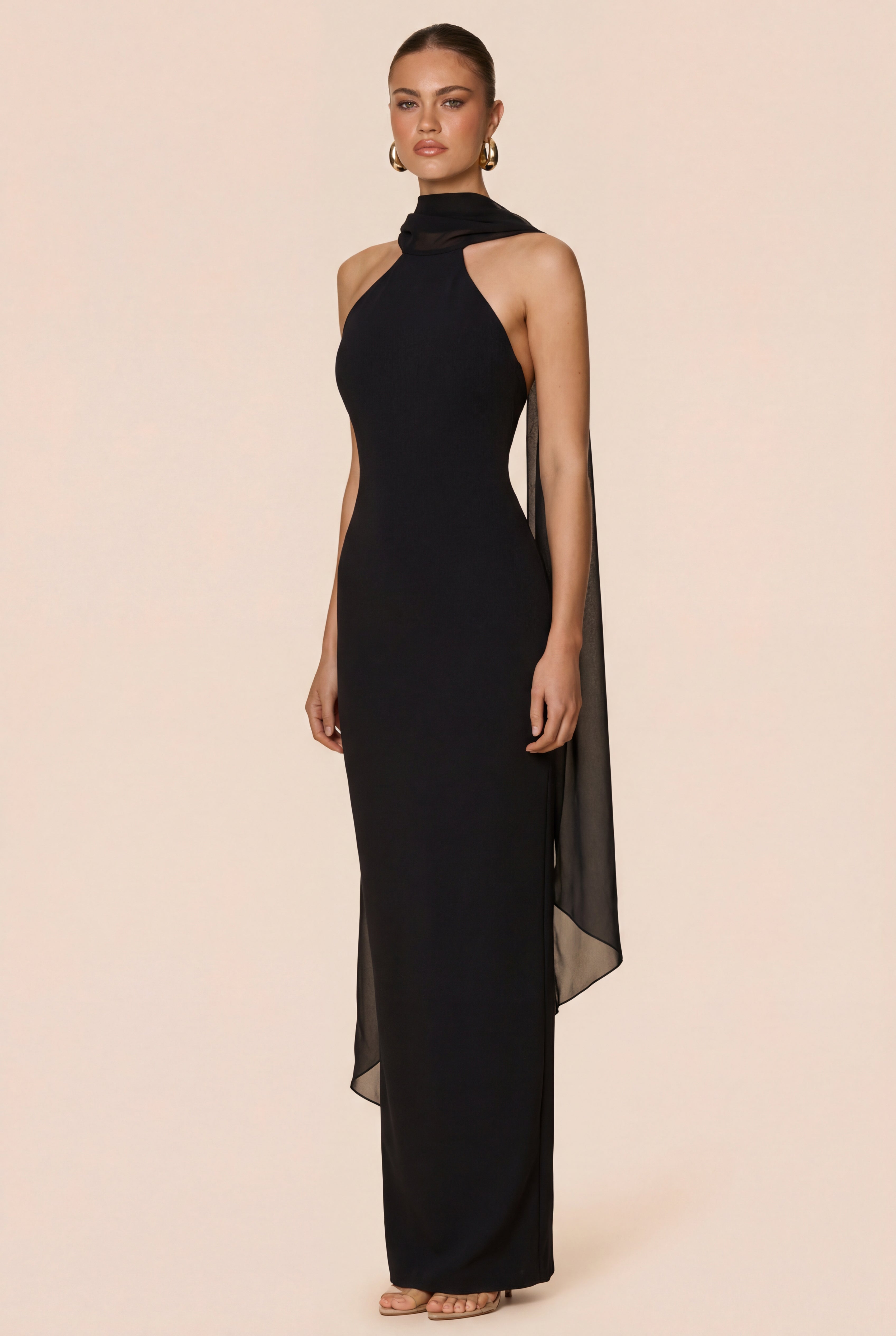 Black evening gown with sheer sides on a beige background