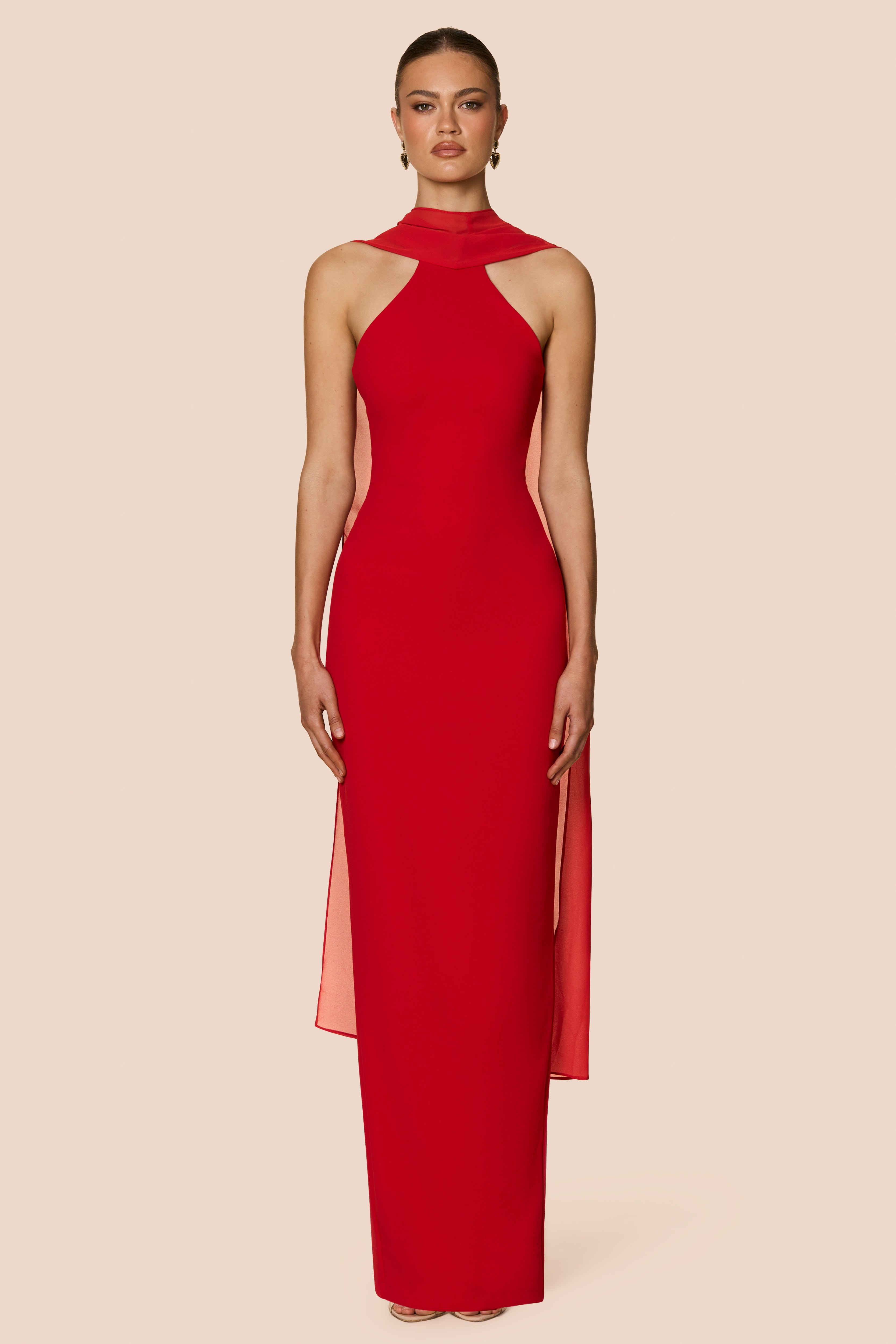 Red halter neck gown on a model against a beige background