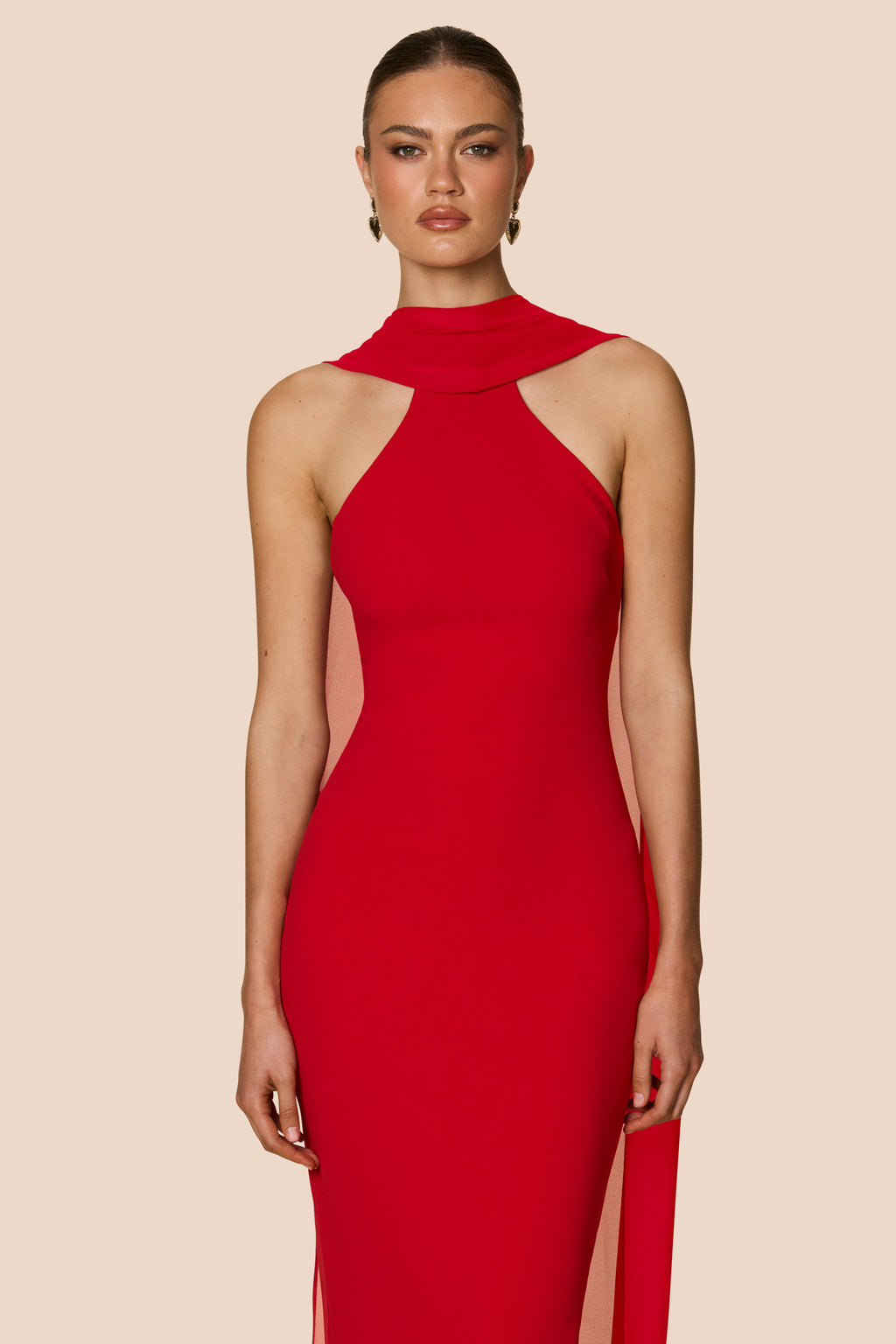 Red dress worn by a model on a beige background