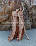 Two women in beige dresses standing against a rocky background with promotional text overlay.