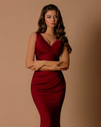 Woman wearing a red dress against a beige background
