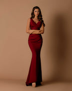 Woman wearing a red evening gown against a beige background