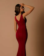 Woman wearing a red evening gown against a beige background