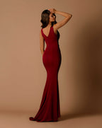 Woman wearing a red evening gown against a beige background
