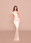 Woman wearing a one-shoulder evening gown on a beige background