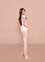 Woman wearing a elegant dress with a high slit on a beige background