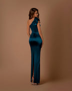 Woman wearing a teal one-shoulder dress against a brown background
