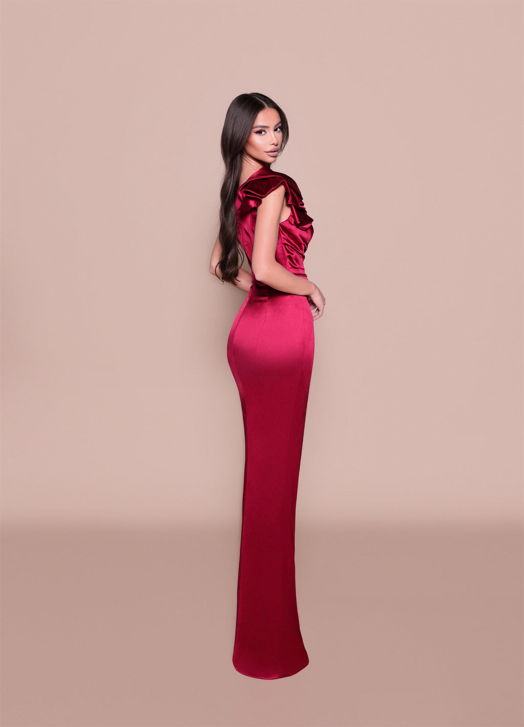 Woman wearing a red evening gown with a beige background