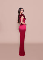 Woman wearing a red evening gown with a beige background