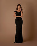 Woman wearing a black off-shoulder gown against a brown background