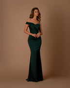 Woman wearing a green off-shoulder gown against a brown background