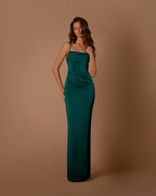 Woman wearing a green evening gown against a brown background