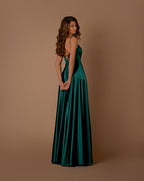 Woman wearing a green evening gown against a brown background
