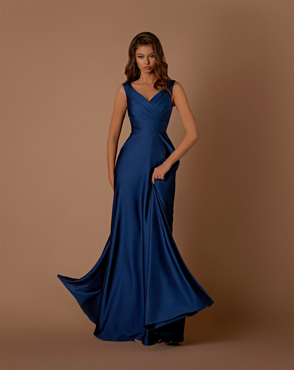 Woman wearing a blue evening gown against a brown background