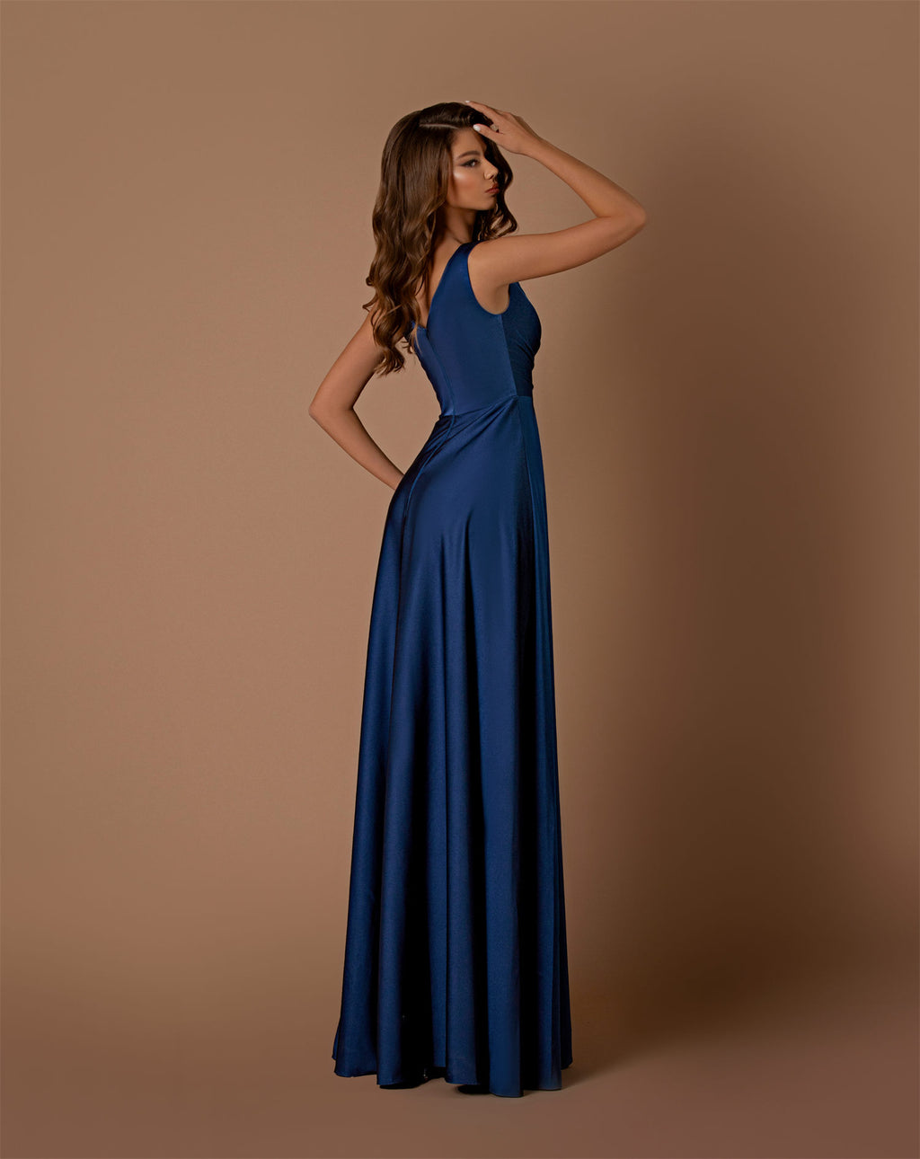 Woman wearing a blue gown against a brown background
