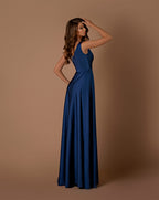 Woman wearing a blue gown against a brown background