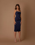 Woman wearing a navy blue dress against a brown background