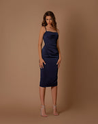 Woman wearing a navy blue dress against a brown background